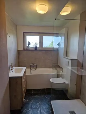 a bathroom with a tub and a toilet and a sink at Villa Kakelbont Borgloon in Borgloon
