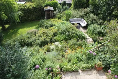 a garden with a bench in the middle of it at Villa Kakelbont Borgloon in Borgloon