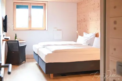 a bedroom with a bed and a window at Sleepwood Hotel in Eupen