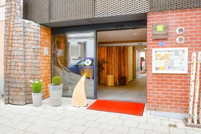 a store front with a red rug in front of a door at Sleepwood Hotel in Eupen