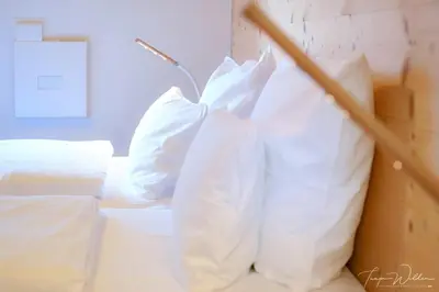 two white pillows sitting on top of a bed at Sleepwood Hotel in Eupen