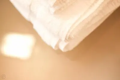 a white towel is hanging on a wall at Sleepwood Hotel in Eupen