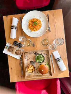 a wooden table with a plate of food on it at Hotel Verviers Van der Valk in Verviers