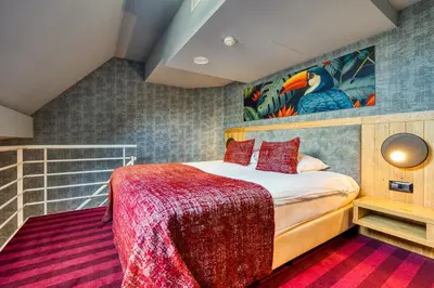 a bedroom with a bed with a red blanket at Hotel Verviers Van der Valk in Verviers