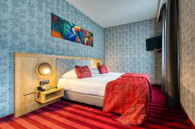 a hotel room with a bed with a red blanket at Hotel Verviers Van der Valk in Verviers