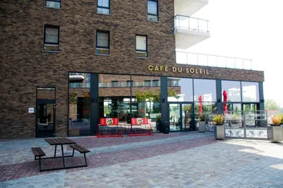 a building with two benches in front of it at Hotel Stayen in Sint-Truiden