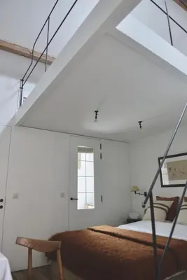 a white room with a bed and a window at Boetiekhotel Hemelhuys in Hasselt