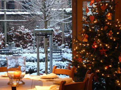 a christmas table with a christmas tree in a room at Boetiekhotel Hemelhuys in Hasselt