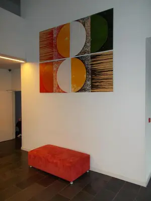 a red stool in front of a painting on a wall at Hotel Corbie Lommel in Lommel