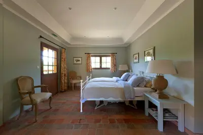 a bedroom with a bed and a table and chairs at B&B Kasteelhoeve de Kerckhem in Wijer