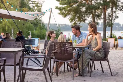 a group of people sitting at a table on the beach at Sunparks Kempense Meren in Mol