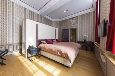 a bedroom with a bed with purple pillows at Van Der Valk Sélys Liège Hotel & Spa in Liège