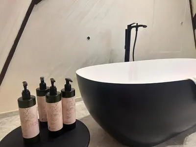 four bottles of wine sitting on a table next to a bath tub at Van Der Valk Sélys Liège Hotel & Spa in Liège