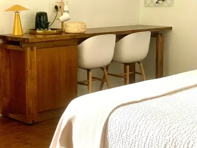 a desk with two white chairs next to a bed at Vakantiewoning Guesthouse MOMO in Dilsen-Stokkem