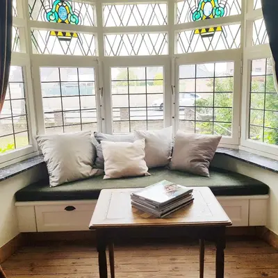 a couch in a room with windows and a table at Vakantiewoning Guesthouse MOMO in Dilsen-Stokkem