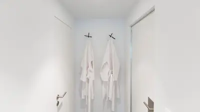 a bathroom with white towels hanging on a wall at côté verger B&B in Battice