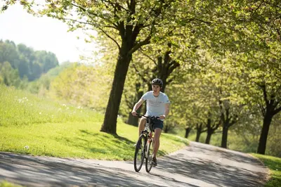 a man riding a bike down a road at côté verger B&B in Battice