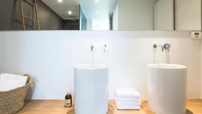 two white vases sitting on the floor in a bathroom at côté verger B&B in Battice
