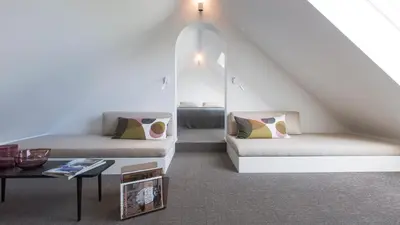 a attic room with two beds and a table at côté verger B&B in Battice