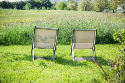 two chairs sitting in the grass in a field at côté verger B&B in Battice