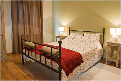 a bedroom with a bed with a red blanket and two lamps at Bosbeekvallei in Opoeteren