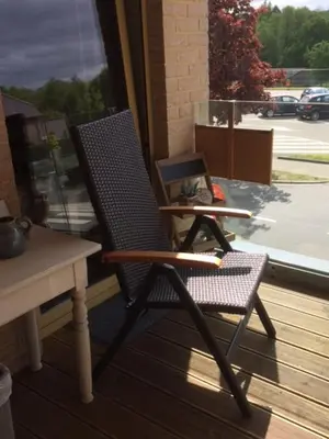 a chair sitting on a porch next to a table at Bosbeekvallei in Opoeteren