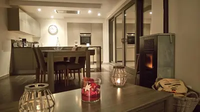 a kitchen and living room with a table and a counter at La renaissance in Villers-lʼÉvêque