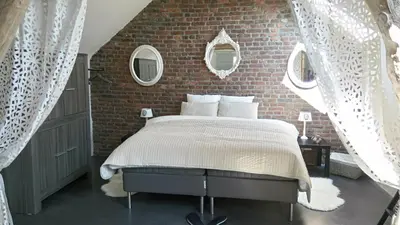 a bedroom with a bed and a brick wall at La renaissance in Villers-lʼÉvêque