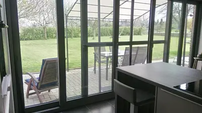 a screened in porch with a table and chairs at La renaissance in Villers-lʼÉvêque