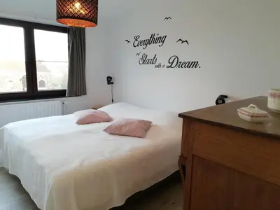 a bedroom with a bed and a sign on the wall at La Balade d'Annie in Trooz