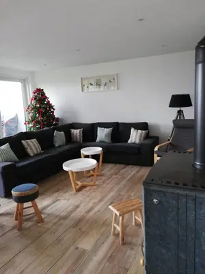 a living room with a black couch and a christmas tree at La Balade d'Annie in Trooz