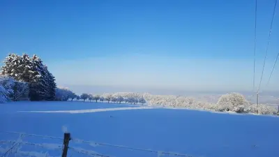 a field covered in snow next to a fence at La Balade d'Annie in Trooz