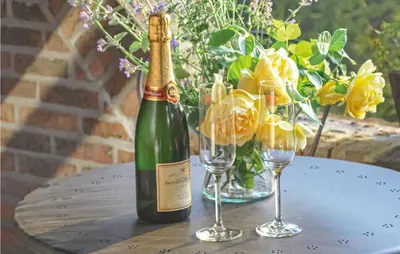 a bottle of champagne and two wine glasses on a table at Holiday Home Kinrooi I in Kinrooi