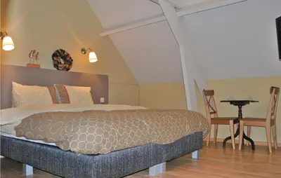 a bedroom with a bed and a table and chairs at Holiday Home Kinrooi I in Kinrooi