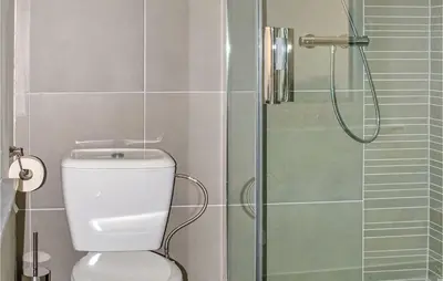 a bathroom with a toilet and a glass shower at Holiday Home Kinrooi I in Kinrooi