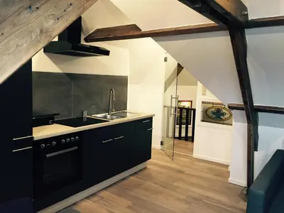a kitchen with black cabinets and a sink at de Twie Keuninge in Maasmechelen