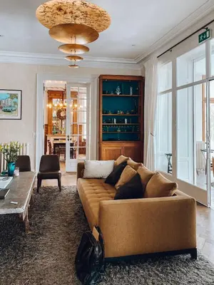 a living room with a brown couch and a table at Château Charles in Pepinster