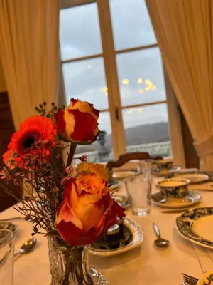 a table with flowers in a vase on a table at Château Charles in Pepinster
