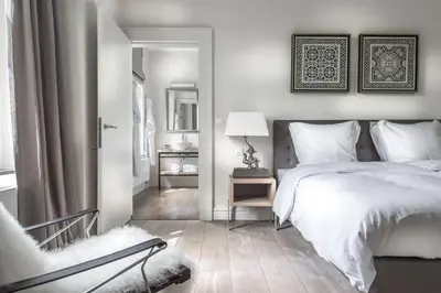 a bedroom with a bed and a chair and a mirror at Château Charles in Pepinster