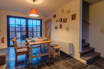 a dining room with a table and chairs and a window at Het Kloosterzicht in Borgloon