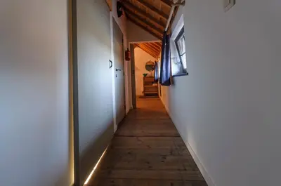 a hallway with a wooden floor and white walls at Het Kloosterzicht in Borgloon