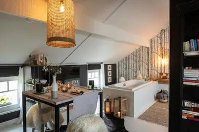 a kitchen with a sink and a tub in a room at Du Coté de chez Jeanne, Suite in Verviers