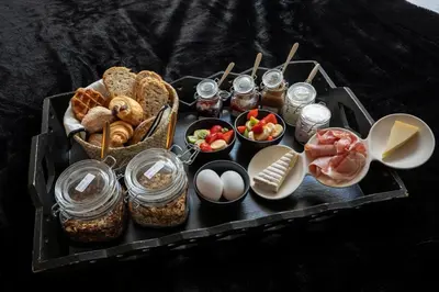 a tray of food with bread and other foods on it at Du Coté de chez Jeanne, Suite in Verviers