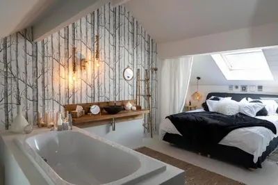 a bedroom with a bed and a bath tub at Du Coté de chez Jeanne, Suite in Verviers