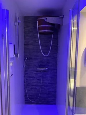 a bathroom with a shower with a hose at Relax Trois Bornes - De Grenspost in Gemmenich