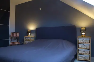 a bedroom with a blue bed and two night stands at 't Gillebroek in Borgloon