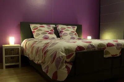 a bedroom with a bed with two candles on it at 't Gillebroek in Borgloon