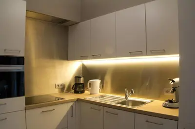 a kitchen with white cabinets and a sink at 't Gillebroek in Borgloon