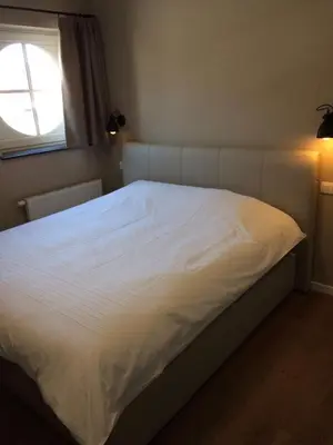 a white bed in a bedroom with a window at Bolderhuys in Bolderberg