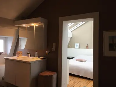 a bathroom with a sink and a bed in a room at Tongeren Schuttersgang 1 in Tongeren
